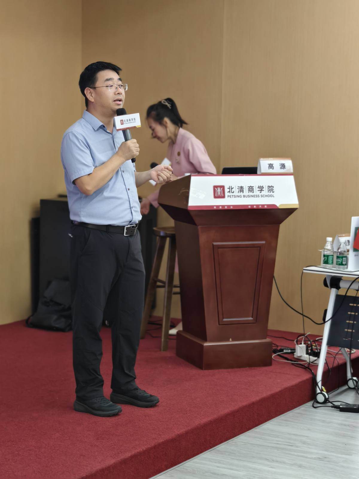 高源老师手持话筒在讲台前授课